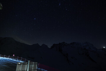 Serene night sky over Zermatt ski resort in the Swiss Alps. Starry night, mountain silhouette,...