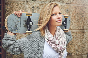 Portrait, skateboard and woman in a city, wall and confidence with hipster and fitness. Face, happy...