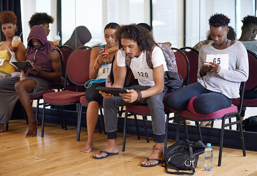 Waiting, line and people in casting audition to sign up for creative performance dancing or acting in studio. Theater, technology and men with women, mobile or cellphone at academy for talent show