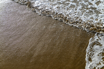 Waves washing ashore on a sandy beach