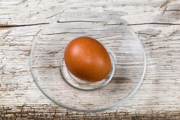 Whole boiled brown chicken egg on glass saucer