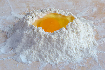 Broken egg on a heap of wheat flour close-up - 781234581