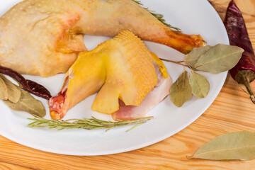 Raw chicken pieces among the different dry spices close-up
