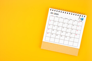 May 2024 desk calendar on yellow color background. - obrazy, fototapety, plakaty