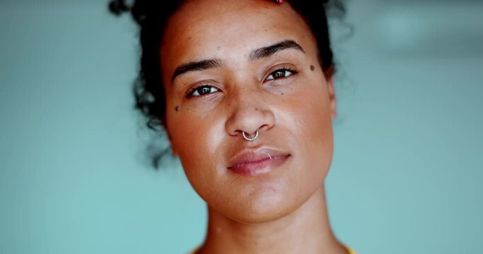 One young black latina woman looking at camera with neutral expression. Female 20s South American person of African descent close-up face