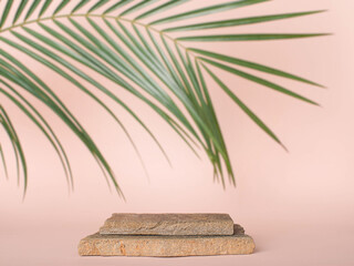Empty stone podium for cosmetics beauty product presentation. Mock up with stones and palm leaf.