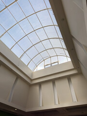 Glass ceiling in blue sky sunlight, abstract. Glass roof of the building. Geometrical ceiling. Glass roof of the building, transparent roof, skylight roof. The shopping center, business center 