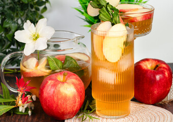Glass of apple cider surrounded by flowers