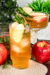 Glass of apple cider surrounded by flowers