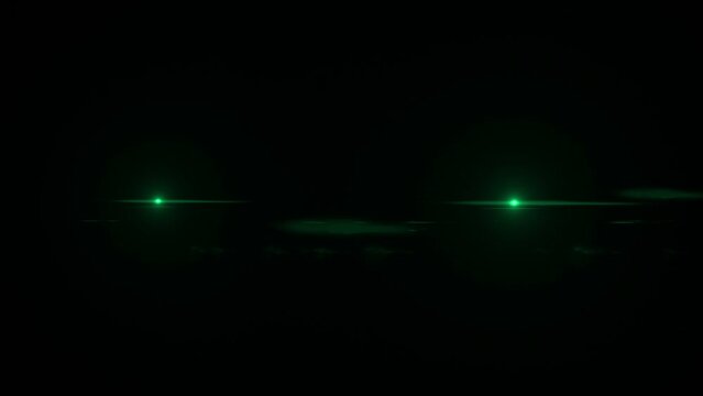 Animation showing two small green lights on a black background moving apart from each other.