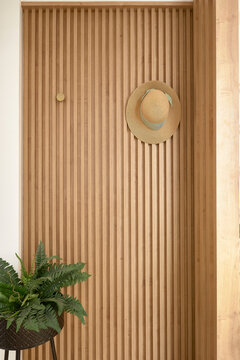Straw hat hanging on a wooden slatted wall