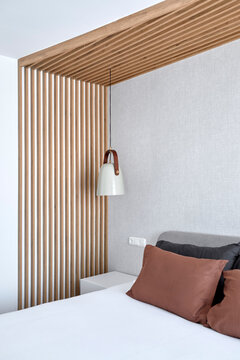 Contemporary bedroom with wooden slat wall and lamp