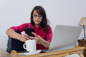 woman at home enjoying her day off watching movies she is using phone ordering food through mobile app