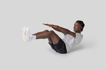 Man performing a V-sit abdominal exercise on white background