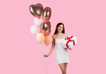 Lady in white dress with balloons and gift