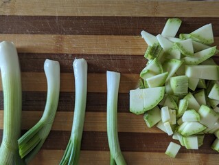 Zucchini and green onion on a chopping wooden board