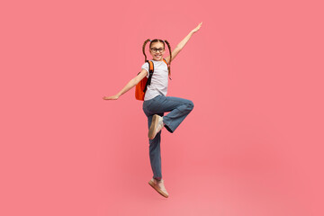 Happy jumping girl with backpack and gesture