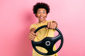 Photo of handsome excited man arms hold wheel beaming smile isolated on pink color background
