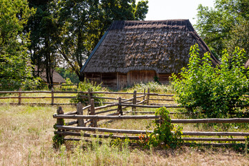 Authentic Ukrainian house in countryside. Summer village in Ukraine. Old folk thatched house. Ukrainian traditional rustic house. Rural countryside in summer ranch. Architecture