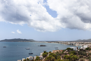 Panoramic view of Ibiza coastline showcases urban development along the waterfront, with yachts and...
