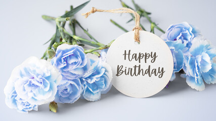 Happy birthday with carnation flowers on blue background