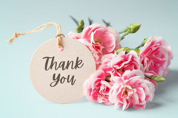 Thank you tag with pink carnation flower bouquet on blue background