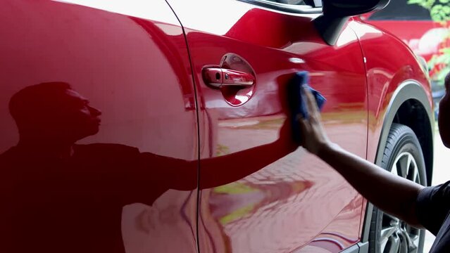 Men apply blackening liquid to the car body, polishing the car parts to restore the black color without being dull.
