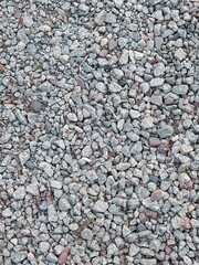 Obraz premium Granite gravel of macadam, rock gray crushed for construction on the ground. Scree texture background. Gravel is a loose aggregation of rock fragments. 