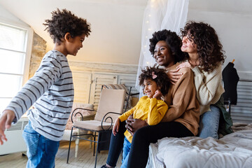 Happy lesbian multiethnic couple in love with children at home. Family lgbt child happiness concept