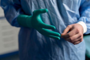 close-up of a doctor's hands a surgeon puts on green latex gloves before an operation