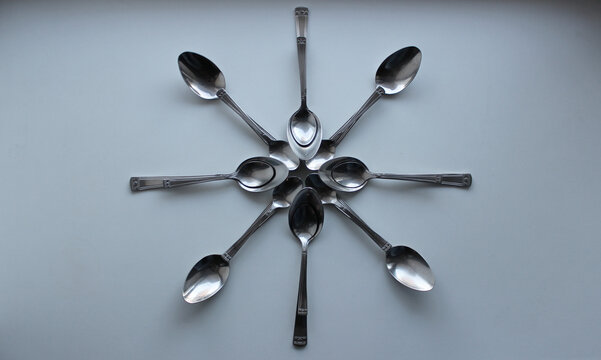 Flower Pattern Made With Variety Size Spoons On White Surface