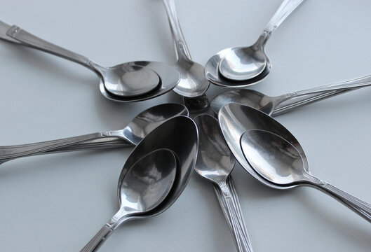 Different Size Spoons On A Clean Plastic Cutting Board Closeup View
