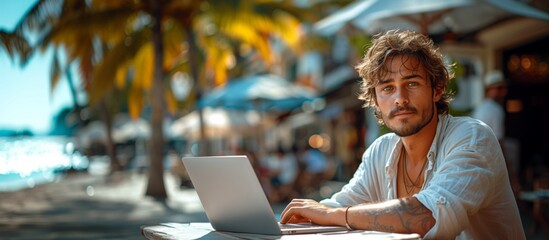 Young man with an opened laptop. He works as a freelancer near beach. Online teacher, student, investor or remote developer
