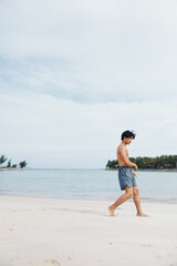 Muscular Asian Athlete Enjoying Cardio Training on the Beach at Sunset