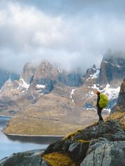 Hiker woman traveling with backpack in Norway hiking in Lofoten islands outdoor activity healthy lifestyle trip adventure vacations, traveler enjoying foggy mountains nature landscape