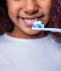 Girl brushing her teeth against a white background. Adorable african american kid brushing teeth. Little girl toothbrush closeup. Little cute african american girl brushing her teeth