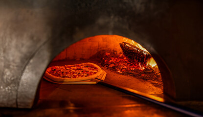 Pizza concept. Preparing traditional italian pizza. Shovel for pizza, baking dough in a oven with...