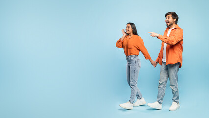 Couple pointing to side and looking surprised - obrazy, fototapety, plakaty