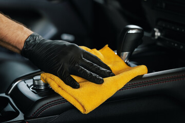 car interior cleaning. closeup of hand with microfiber cloth on center console - 781312791