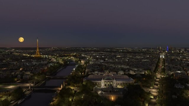 Aerial view at night with full moon of the city of Paris. France
