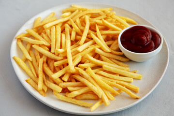 Fried French Fries with Ketchup on a Plate, side view.