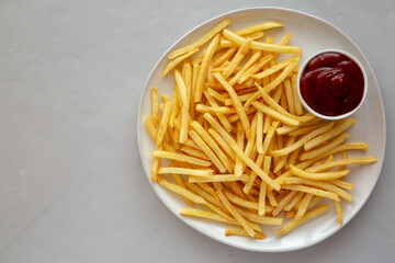 Fried French Fries with Ketchup on a Plate, top view. Flat lay, overhead, from above. Copy space.