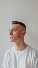 Young Man with Modern Undercut Hairstyle Posing Against White Background.
