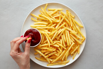 Woman dipping French Fries into Ketchup, top view. Flat lay. - 781313729