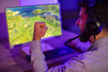Gamer with fist clenched in front of screen