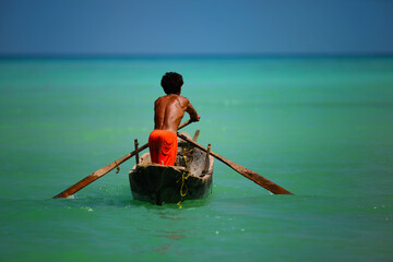 Urak Lawoi (the Thailand sea gypsies) paddle his dredger for fishing as usual in their way of life