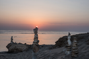 sun lies on a stacked tower of corals on the beach during sunrise