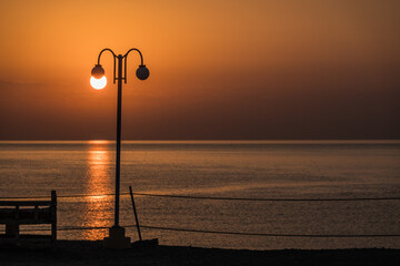 white glowing sun on a lantern during sunrise at the red sea