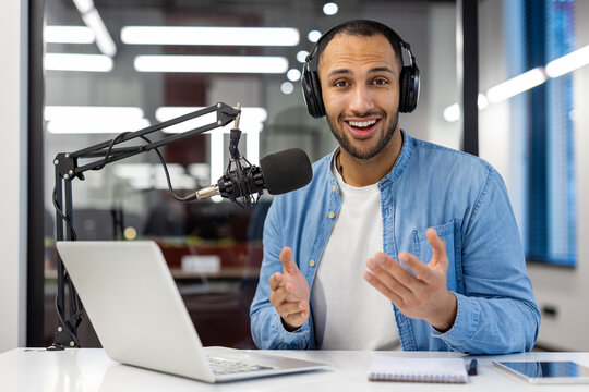 Indian man podcasting from home in a cozy living room setting