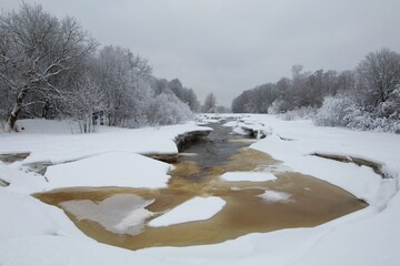 Rapids on Vantaanjoki river in cloudy winter weather with snow on the ice and ground, Ruutunkoski...